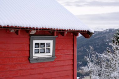 Norheimsund, Norveç 'te kışın, karlı bir ormanda, rahatlatıcı, kırmızı bir kulübede..