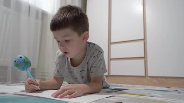 Mały Chłopiec Uczy Się Rysować Ołówkiem Kształcie Planety Ziemia — Wideo stockowe