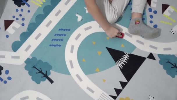 Малюк Грає Іграшковими Автомобілями Килимі Іграшкові Автомобілі Їдуть Дорогою — стокове відео