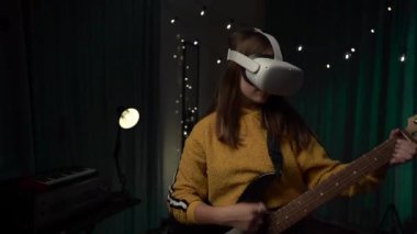 VR kulaklıklı bir kız gitar çalan neşeli bir kız giyilebilir VR, ev teknolojisi, düşük ışık.