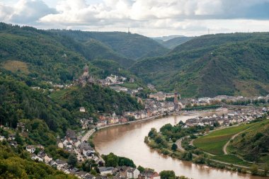 Cochem Town ve Moselle River Panorama Kalesi ve Bulutlu Gökyüzü altında Yeşil Sonbahar Ağaçları, Almanya