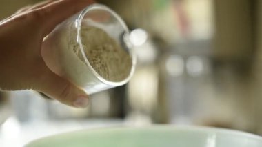 Karıştırma kabına un döken bir kadının yüksek kaliteli HD videosu. Bu klip pişirme sürecinde ev yemeği ve pişirmeyi sembolize eden önemli bir adımı yakalıyor.. 