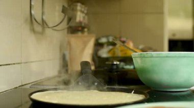 Yüksek kaliteli Full HD video çerçevesi siyah yapışmaz tavada kızaran ince bir krep yakalar ve buhar yavaşça yükselir. Lezzetli bir kahvaltı ya da tatil ziyafeti hazırlayan davetkar bir sahne..