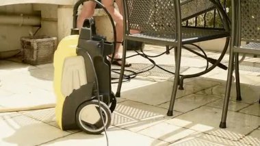 Profesyonel biri veranda ve garaj yollarındaki kiri endüstriyel basınçlı yıkama ekipmanlarıyla temizliyor. Temizlik hizmetleri ya da ağır yıkama için mükemmel.. 