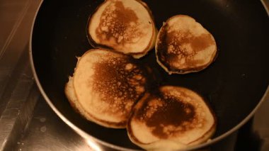 Siyah tavada kızaran dört geleneksel Ukrayna gözlemesi. Altın-kahverengi yüzey ve kabarcıklı doku lezzetli bir ev yapımı yemek hazırlığını ön plana çıkarıyor. Tam HD görüntüler.