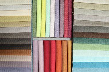 Döşeme ve perde tasarımı için renkli kumaş kumaş kumaş paleti. Çeşitli tekstil örnekleri bir kumaş galerisinin örnek tahtasına yerleştirilmiş. İç mimarlar ve alıcılar için tam bir renk yelpazesi sergileniyor..