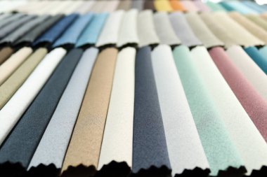 Döşeme ve perde tasarımı için renkli kumaş kumaş kumaş paleti. Çeşitli tekstil örnekleri bir kumaş galerisinin örnek tahtasına yerleştirilmiş. İç mimarlar ve alıcılar için tam bir renk yelpazesi sergileniyor..