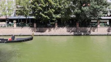 Eskisehir, Türkiye - 14 Eylül 2025. Yolcuları taşıyan bir gondol Eskisehir 'de manzaralı bir kanal boyunca yüzerek huzurlu bir su yolu sahnesini yakalıyor. Sadece editör kullanımı