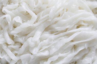 Çiğ ve pişmemiş kway teow (taze düz pirinç eriştesi), tam çerçeve görünümlü, ipeksi dokusu ve kurdele benzeri şekilleri sergilenmektedir..