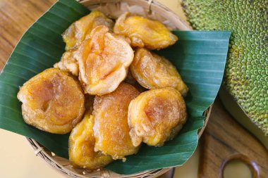 A traditional basket bowl lined with a banana leaf and filled with pieces of freshly fried cempedak (or chempedak).
