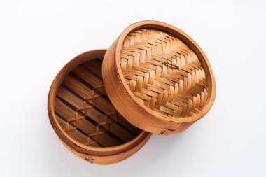 Overhead shot of a traditional bamboo steamer with its lid open and resting on the side, on a white background.
