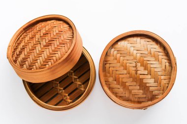 Overhead shot of two traditional bamboo steamers on a white background, one open and one closed, showcasing the set from a top-down perspective.