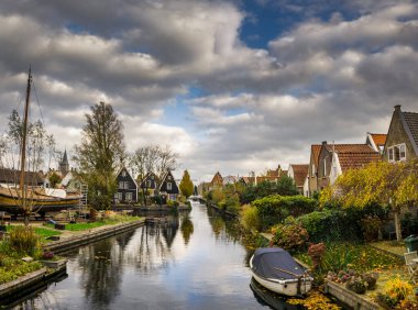 Hollanda, Giethoorn 'un sakin kanalları boyunca uzanan büyüleyici geleneksel Hollanda evi samanlı çatılar, canlı çiçek bahçeleri ve pitoresk ahşap köprüler ile süslenmiş.