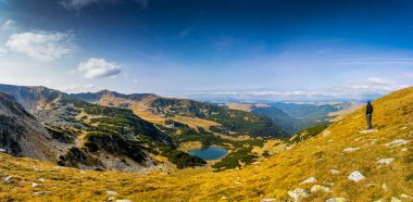 Romanya 'nın Parang Dağları' ndaki Galcescu Gölü yakınlarındaki vahşi Karpatlar 'da nefes kesici bir sonbahar günü yaşayın. Renklerin engebeli doruklarla buluştuğu Parang Dağları' nda.