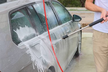 Araba yıkamada yıkanır. Basınçlı su jeti arabanın yüzeyini toz ve çamurdan temizler. Yüksek kalite fotoğraf