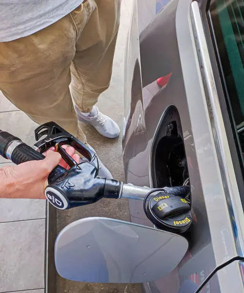 Adam arabaya dizel yakıt dolduruyor. dikey resim