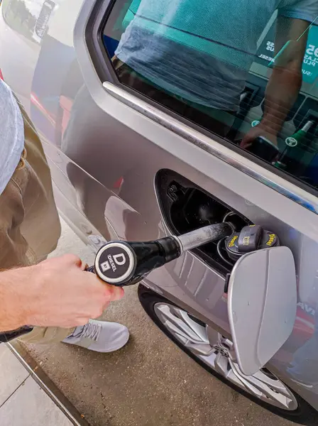 Adam arabaya dizel yakıt dolduruyor. dikey resim