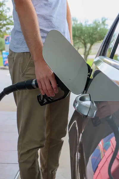 Adam arabaya dizel yakıt dolduruyor. dikey resim