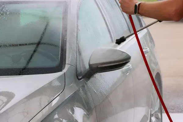 Araba yıkamada yıkanır. Basınçlı su jeti arabanın yüzeyini toz ve çamurdan temizler. Yüksek kalite fotoğraf