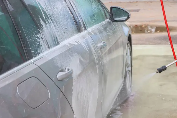 Araba yıkamada yıkanır. Basınçlı su jeti arabanın yüzeyini toz ve çamurdan temizler. Yüksek kalite fotoğraf