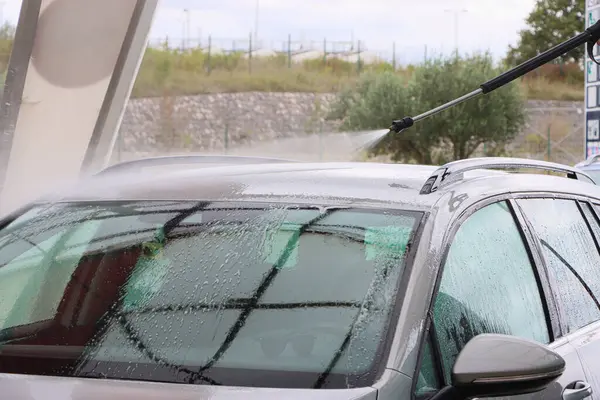 Araba yıkamada yıkanır. Basınçlı su jeti arabanın yüzeyini toz ve çamurdan temizler. Yüksek kalite fotoğraf