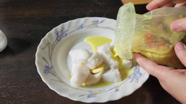 Ev Mutfağı Sahnesi: Yemek hazırlama sırasında tabağın üzerine sıkıştırılmış pirinç küpleriyle sarı sos dökülüyor