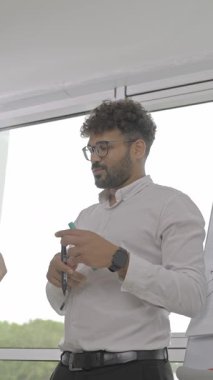 Bir iş toplantısında ekip üyeleriyle aktif olarak ilgilenen ve fikir birliği yapan bir profesyonel..