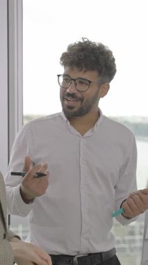 Sadık bir yaratıcı ekip üyesi verimli bir toplantı sırasında meslektaşlarıyla yaratıcı fikirleri tutkuyla tartışıyor.