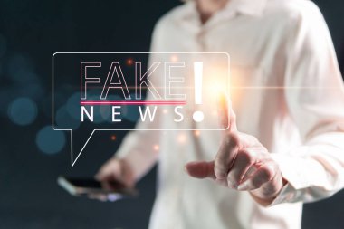 Sahte haberler, yanlış bilgi sunma konsepti, kazanç veya zarar, karalama veya itibara zarar verme amacıyla aldatma. İş adamı gelen haberleri analiz etmek için telefonu kullandı.