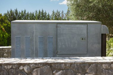 Doğal manzaraya karşı açık alanda havalandırma ızgaraları olan metal malzeme dolabı.