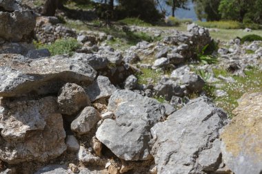 Yıpranmış kireçtaşı blokları ve taş işçiliğini gösteren antik taş yapısının yakın plan detayları.