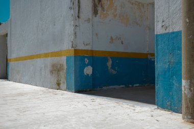 Akdeniz köşesinde kabuk soyan boya ve geleneksel mavi-beyaz renk şeması.