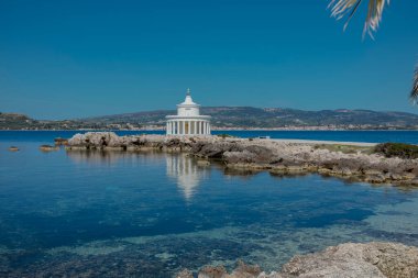 Kristal berrak Akdeniz sularında duran sütunları olan ikonik beyaz neoklasik pavyon.