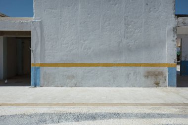 Yıpranmış Akdeniz binası, kemerli açıkları ve liman yakınlarında geleneksel mavi panjurları var..