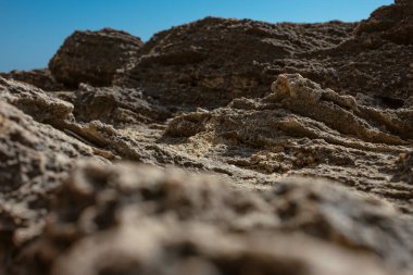 Sanatsal sığ alan derinliği doğal bokeh etkisine sahip aşınmış kireçtaşı kıyı oluşumlarını yakalıyor.