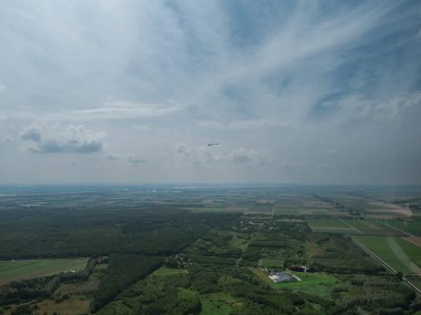 Planör kokpitinden geniş bir hava manzarası başka bir uçağın tarımsal araziye uzaklığını gösteriyor.