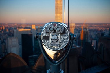 Gözlem güvertesinde turist teleskopu, New York şehrinin altın saatinde gökyüzü manzaralı şehir manzarası yaratıyor.