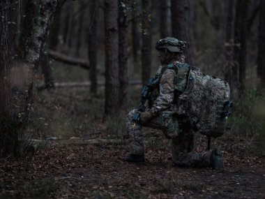Ormanda taktik teçhizat ve iletişim ekipmanlarıyla donatılmış tek bir asker.