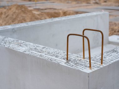 İnşaat alanının temelinden çıkan çelik destekli beton yapı elementleri.