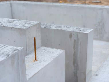 Organize inşaat alanında çelik takviye çubukları olan beton yapı taşları.