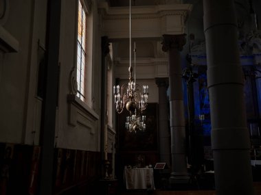 Süslü pirinç avizesi ve zarif dini mimariyi gösteren klasik sütunlarla tarihi kilise iç mimarisi