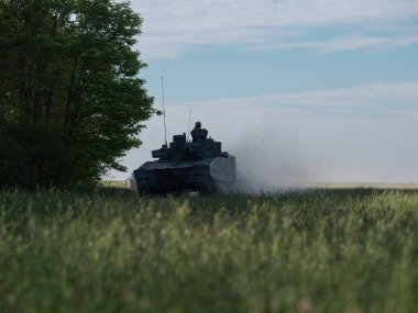 Yalnız tank, orman arka planında duman bulutu yaratıyor.