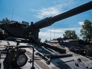 Mavi gökyüzü arka planına sahip askeri tank taret ve topun yakın görüntüsü.