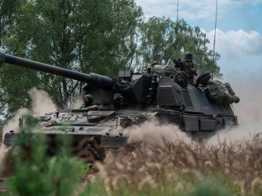 PZH2000NL topçu birliğinin yakın görüntüsü çayır boyunca ilerleyen görünür mürettebatla