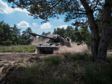 PZH2000NL topçular ağaçların altında hareket ederek doğal ortamda toz bulutu oluşturuyor