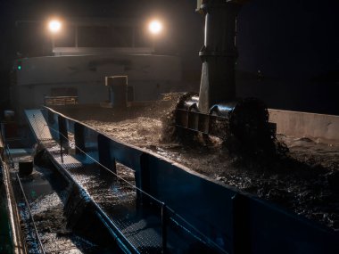 Endüstriyel tarama ekipmanlarının kesme mekanizmaları ve malzeme işleme ile gece çalışan yakın görüntüsü