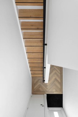 Ahşap kaplamalı modern merdiven, beyaz yapı ve iç mekanlarda geometrik tasarım.