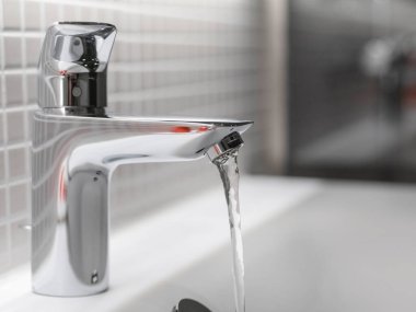 Kırmızı mozaik duvardaki beyaz pisuvar. Geniş pencereli. Otoyol ve ulaşım altyapısını gösteriyor.