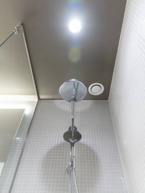 Kırmızı mozaik duvarlar ve dekoratif çiçek düzenlemeleri ile panoramik şehir manzaralı yüksek katlı tuvaletler.