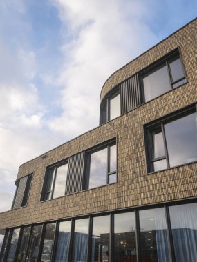 Çağdaş kıvrımlı dış yapı tuğla cepheli büyük pencereler ve modern mimari tasarım elementleriyle